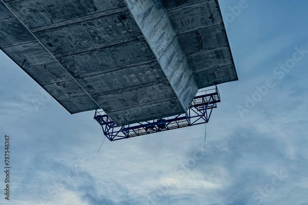 Fototapeta concrete bridge under construction, seen from below with the roadway suspended in the air against a blue skyCrown Princess Marys bridge hangs in the air connecting to the next pylon