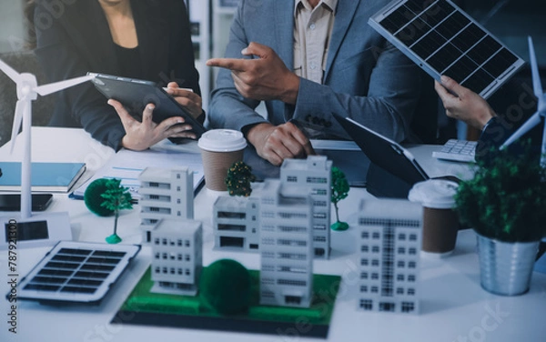 Fototapeta Green energy business company meeting with business people planning and discuss marketing of sustainable and renewable clean energy product with solar cell and wind turbine generator. Trailblazing