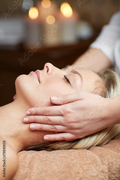 Fototapeta close up of woman having face massage in spa