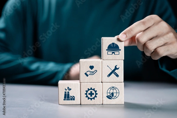 Fototapeta HSE, Health safety environment concept. Standard safe industrial work and industrial. Person stacking wooden block with HSE icon for business and organization.