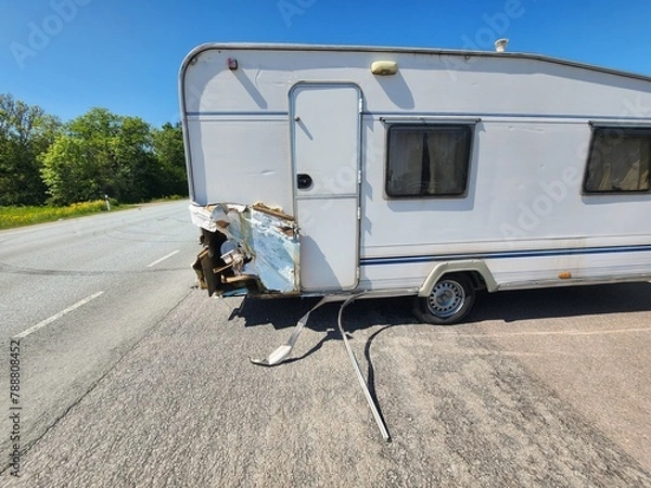 Fototapeta Vintage White Small Travel Trailer with Significant Damage on Rear, Perfect for Fixer-Upper Enthusiasts and DIY Renovation Projects. Great Opportunity for Restoration and Customization.