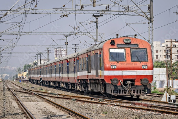 Obraz Indian Railways Diesel-Electric Multiple Unit local train exiting out of a wayside station near Pune