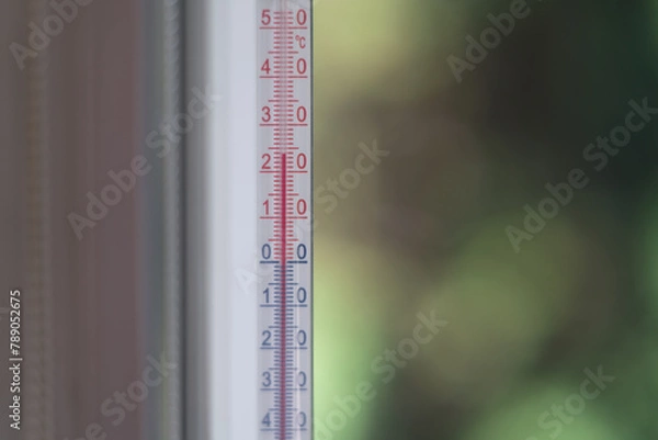 Obraz Outdoor thermometer behind the glass on a green blurred background