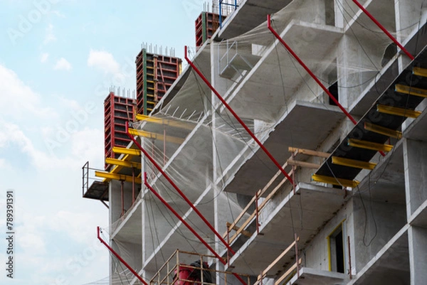 Fototapeta protective catching mesh on a multi-storey building under construction.