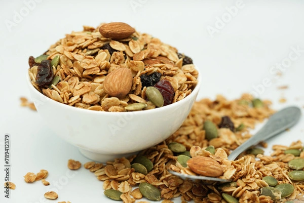 Obraz Close up of Homemade granola with mix nuts in a white bowl. Healthy snack and breakfast.