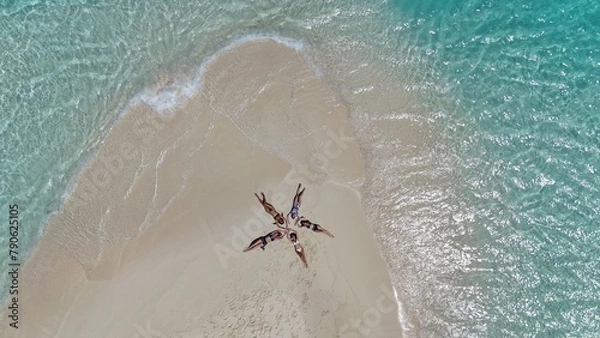 Fototapeta People are lying on the beach with white sand.