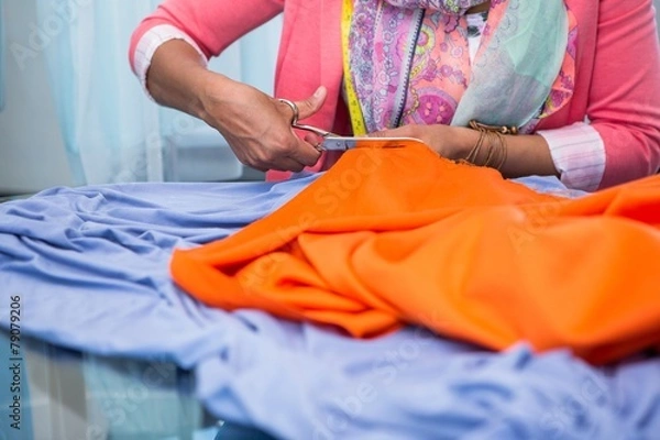 Fototapeta Hands cutting fabric at table