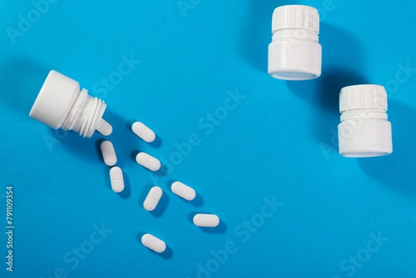 Obraz Bottles with fentanyl tablets on blue background.