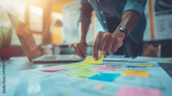 Fototapeta close up hand creative designer team casual meeting and brainstroming on desk with paperwrok and online data on laptop in meeting room at modern office.business planning concept