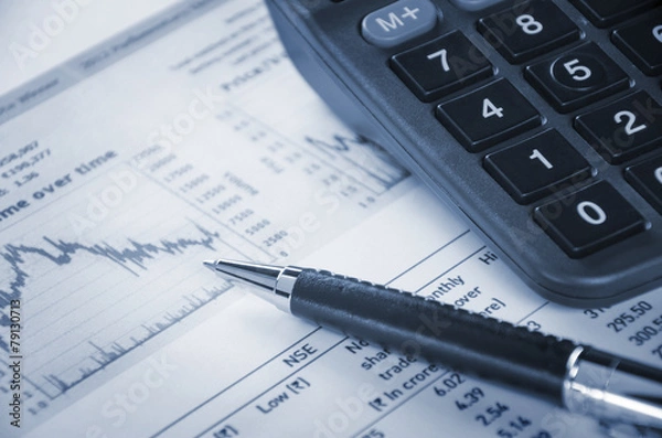 Fototapeta A pen and a calculator with financial graph