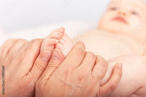 Fototapeta Physiotherapist performing development exercise with infant
