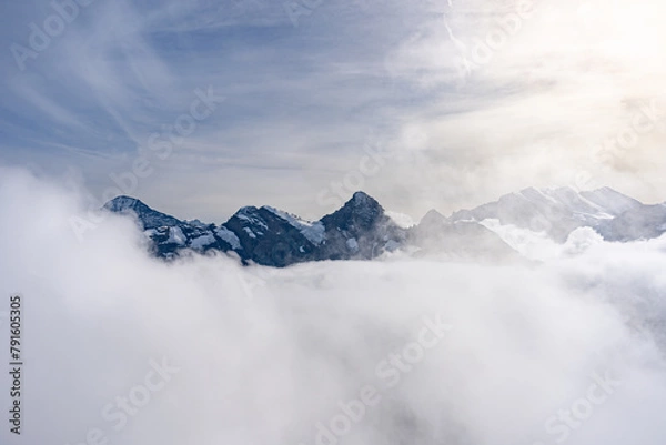 Fototapeta View of Swiss Alps over clouds on a bright sunny day from Schilthorn summit in Switzerland