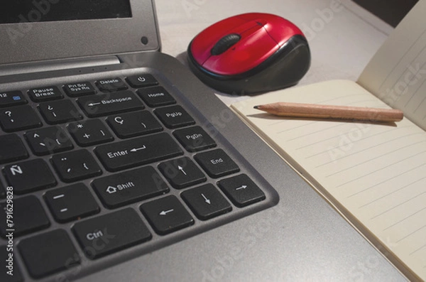 Fototapeta computer keyboard or notebook, with a red mouse and notepad with pencil, work at home concept