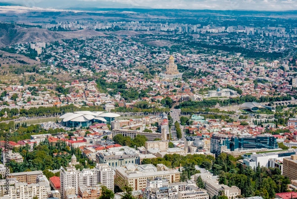 Fototapeta View on the capital city of Tbilisi and the Sameba cathedral from Mtatsminda park (Georgia) 