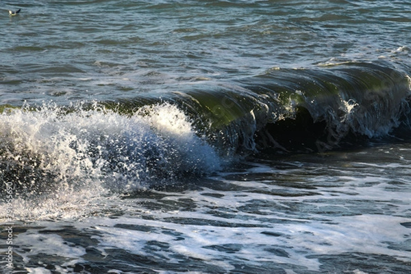 Fototapeta Clear wavy sea water. Splashes of waves break on the rocks. Sea surf on the beach. The power of water on the sea surf. Splashes of sea waves.