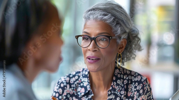 Fototapeta Mature Professional Businesswoman Collaborating With Colleague In Modern Office Setting