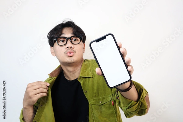 Obraz Adult Asian man smiling happy while showing his mobile phone screen and pointing on it