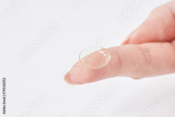 Fototapeta コンタクトレンズを持つ女性の指
