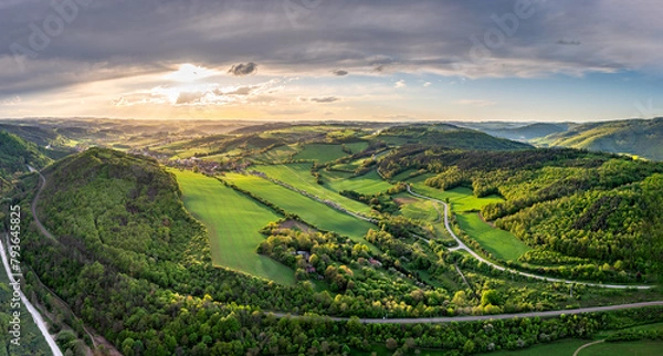 Fototapeta Aerial panoramic shot of Czech highlands during magical sunset with beautiful sky and green meadows and fields and trees in blossom during spring