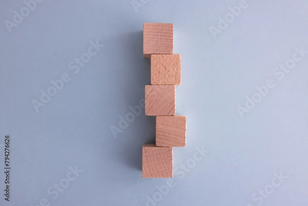 Fototapeta Hand arranging wood cube stacking as step stair. Business concept growth success process on blue background, copy space.