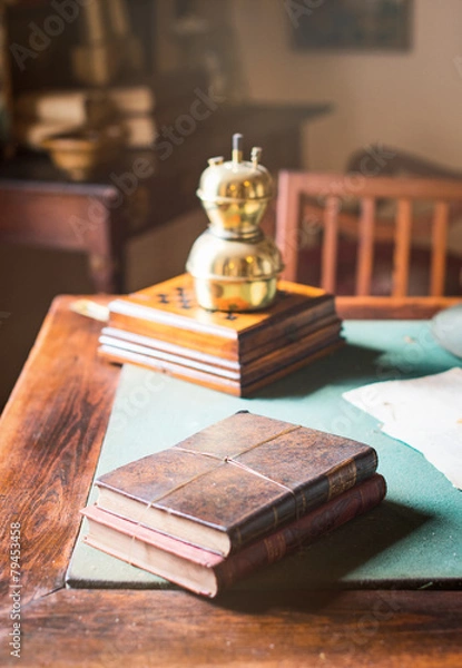 Fototapeta Old books lying on the dusty table.