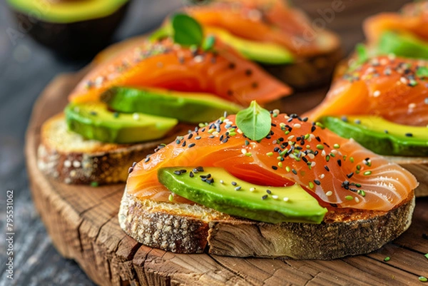 Fototapeta Close-Up Smoked Salmon Avocado Toasts. Close-up of smoked salmon avocado toasts on a rustic board, ideal for food and nutrition themes.