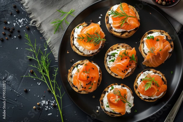 Fototapeta Top View Elegant Salmon Canapes. Top view of elegant salmon canapes on a dark plate, ideal for festive occasions.