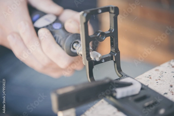 Obraz Sanding a miniature figure in the clutch with a dremel machine