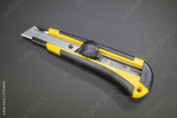 Obraz Utility knife with yellow plastic handle and rubber insert