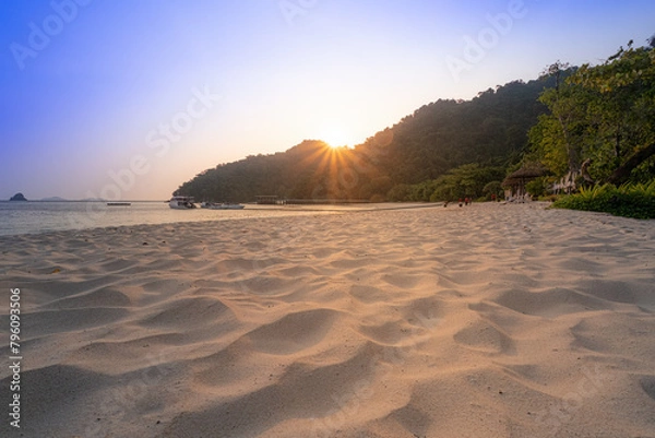 Obraz Golden hour sunlight bathes a secluded beach, highlighting the textured sand and tranquil scenery