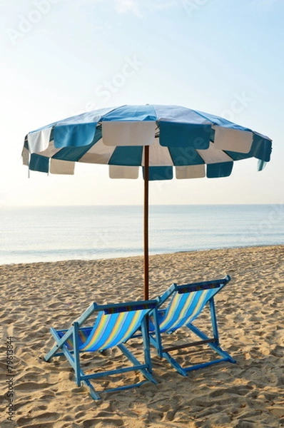 Fototapeta beach canvas beds with blue and white umbrella