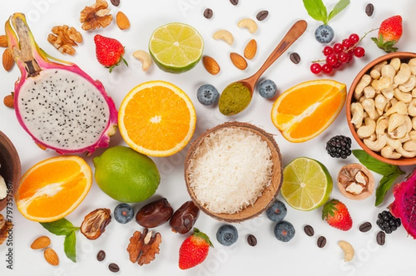 Fototapeta Assorted fresh fruits and nuts on a white background. Ingredients for a healthy dish