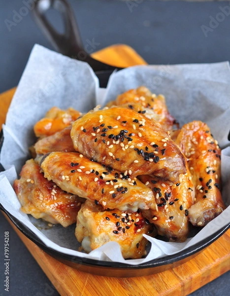 Fototapeta Chicken wings in a sweet and sour sauce with sesame on the pan