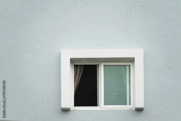 Fototapeta A window with a white frame and a white curtain