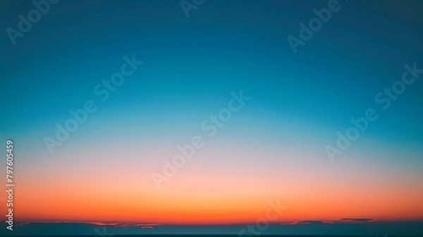 Fototapeta At sunset, the sky displays a beautiful gradient of orange to blue, creating a breathtaking and picturesque view.