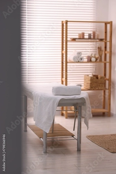 Fototapeta Comfortable massage table with clean towels in spa center