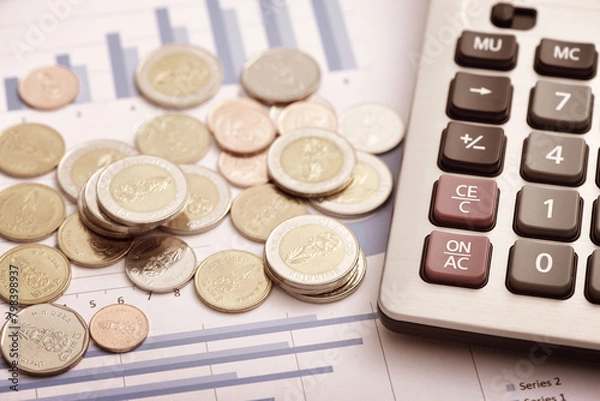 Obraz Coins and calculators placed on financial data reports