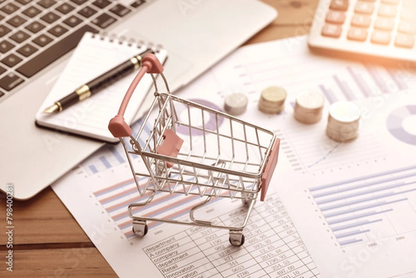 Obraz Coins, carts, and office supplies placed on data sheets