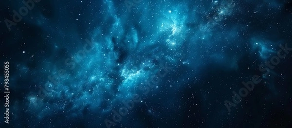 Fototapeta An intricate blue galaxy filled with numerous stars set against a stark black background, creating a mesmerizing cosmic scene