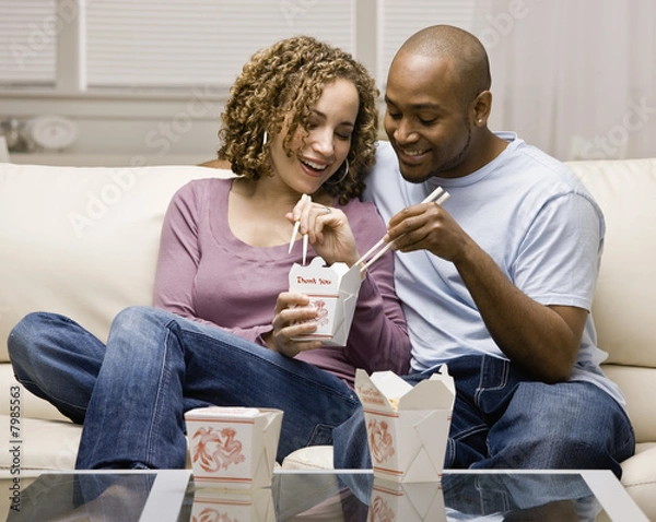 Fototapeta Young couple eating take-out food