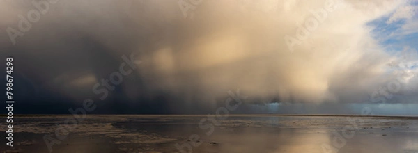 Fototapeta Beautiful moody storm skies over ocean panorama landscape with distant heavy rainfall