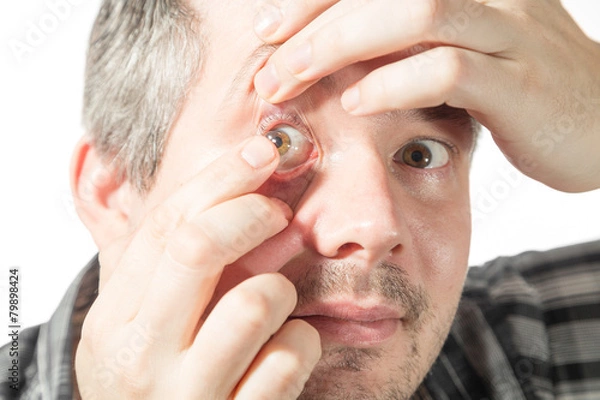 Obraz putting on a contact lens