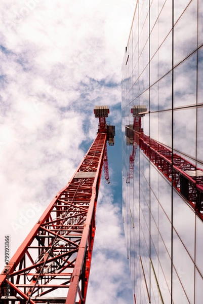 Fototapeta Red crane reflected on glass building 
