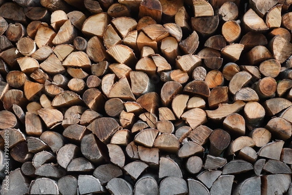 Fototapeta Stack of split raw wood logs as fuel for heating. Firewood pattern background