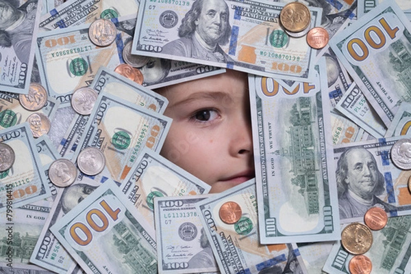Fototapeta Kid with fun face in money. Kid peeking out of dollar bills with astonished shocked eyes. Money background. Shopping and financial concept. Money and banking.