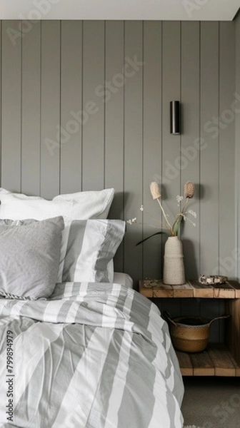 Fototapeta A bedroom with a grey wall and a wooden nightstand