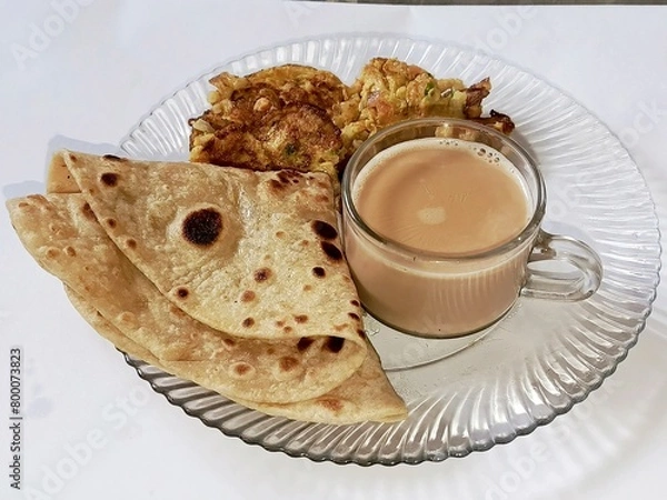 Obraz Pakistani breakfast with desi paratha, omelet and with a cup of tea    
