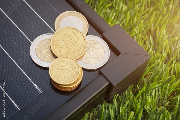 Fototapeta The heap of euro coins on the solar panel for energy generation. The European electricity generation price concept.