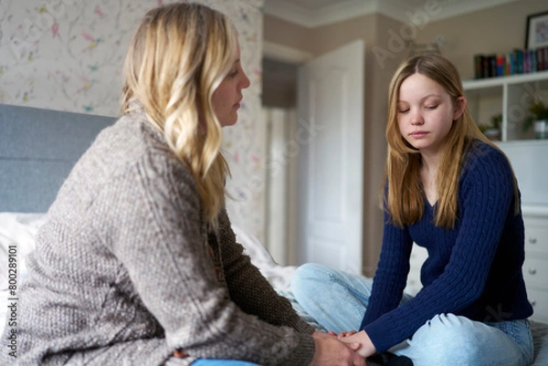 Obraz Mature Mother Sitting On Bed With Unhappy Teenage Daughter At Home Discussing Problem