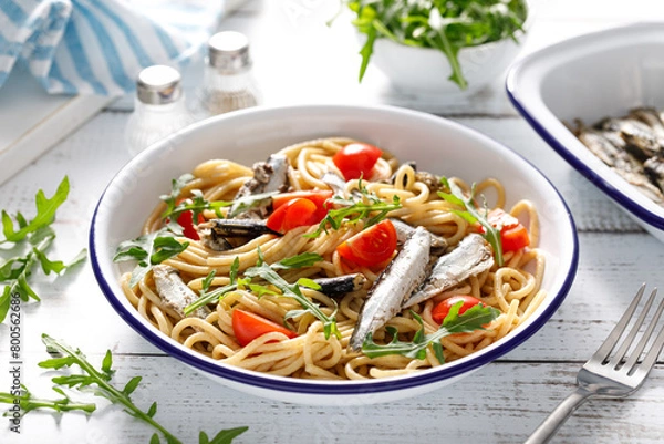 Fototapeta Whole grain pasta with sardines, tomato and arugula. Italian Sicilian cuisine.